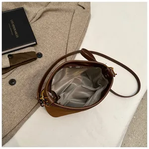 Internal view of brown suede bucket bag featuring silver-grey lining and pockets