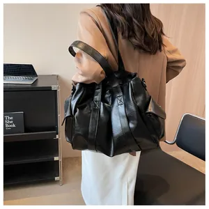 Vue arrière d'un mannequin portant un grand sac cabas noir en cuir avec poches latérales