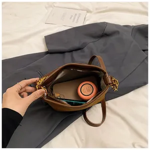 Top view of brown leather bag interior showing space for phone and makeup items