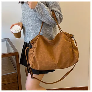 Detailed view of caramel brown tote bag with matte leather texture and adjustable strap