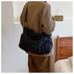 Minimalist black large capacity shoulder bag made of thick fabric with leather strap
