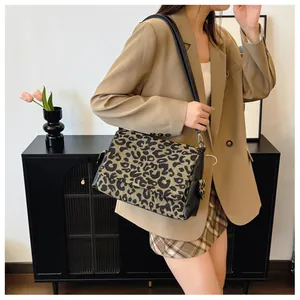 Detail shot of leopard print tote bag with leather straps on a fashion model