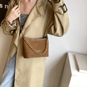 Brown suede-texture bucket bag with chunky gold chain strap and leather handle