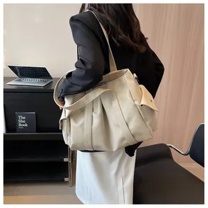 Vue détaillée du sac cabas en cuir crème avec design plissé et poches latérales à rabat