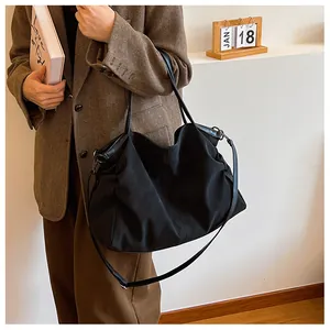 Close-up of black tote bag showing soft fabric texture and dual carrying straps