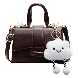 Vintage brown shoulder bag with a cute white cloud plush pendant and top handle