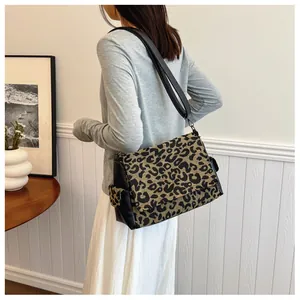 Detail of trendy leopard print flap and black leather texture on stylish tote bag