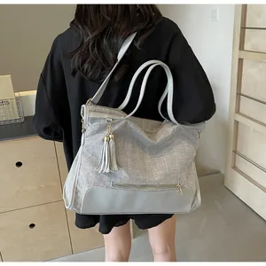 Détail du grand sac cabas argenté pailleté avec cuir gris et pompon élégant