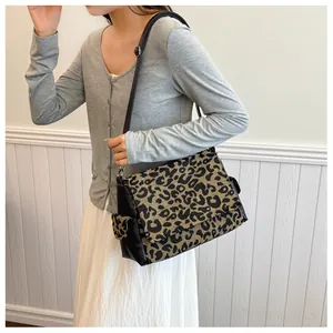 Detail of vintage leopard print crossbody bag with black faux leather and adjustable strap