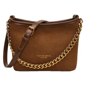 Brown suede bucket bag with chunky gold chain and adjustable leather shoulder strap