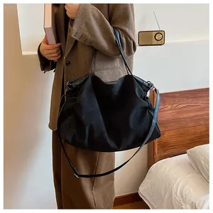 Detail of black large capacity tote bag featuring adjustable strap in retro indoor setting