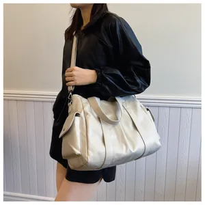 Side view of cream large tote bag with flap pocket on a model in a minimalist room