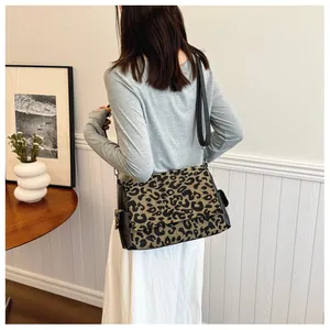 Detailed view of fashionable leopard print crossbody bag with adjustable black shoulder strap