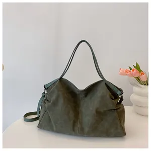 Macro view of dark green large tote bag with pleated details and soft matte texture