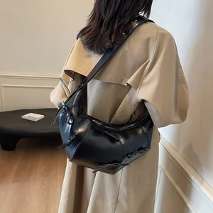 Sac fourre-tout croissant en cuir noir avec nœuds décoratifs et large bandoulière chic