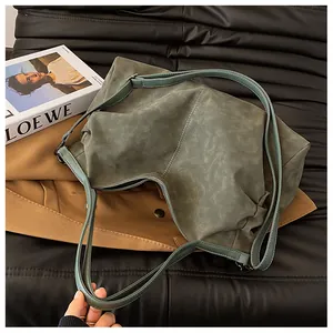 Detail of dark green tote bag showing smooth matte texture and thin shoulder straps