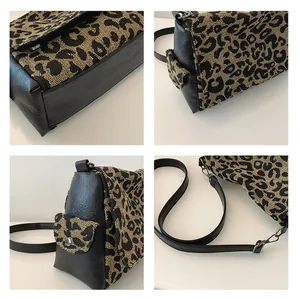 Detail of leopard print canvas tote featuring side pocket and black leather trim accents