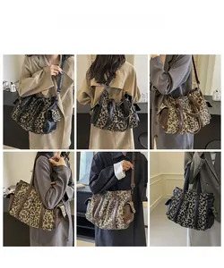Detail view of leopard print tote bag featuring leather handles and side flap pocket