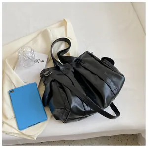 Détail d'un cabas noir en cuir PU avec poche latérale et ferrures métalliques rétro sur tissu