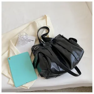 Détail du sac cabas en cuir noir avec ferrures argentées et poche latérale sur table