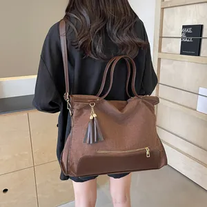 Grand sac fourre-tout en tissu marron avec finitions cuir PU et pompon sur modèle