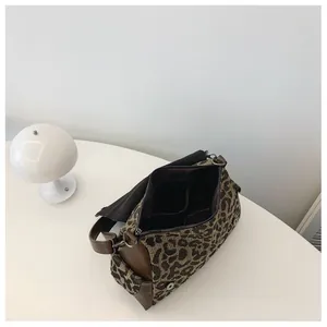 Macro view of leopard print crossbody bag with zipper compartment and interior pockets
