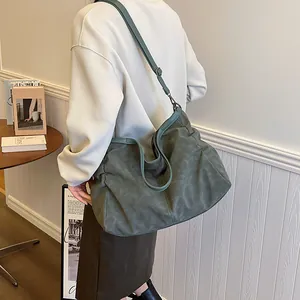 Large dark green tote bag with matte texture and slouchy design shown on model