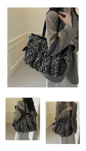Close-up of leopard print canvas tote bag with black leather trim and side pockets
