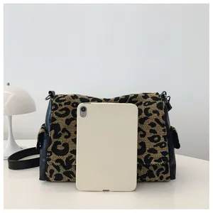Large leopard print tote bag with side pockets showing capacity with a tablet