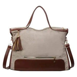 Grand sac cabas en toile beige avec bordure en cuir marron et pompon en vue de face
