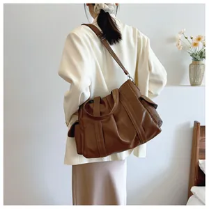 Detail der dunkelbraunen Leder-Tote-Bag mit verstellbarem Riemen und Vintage-Seitentasche