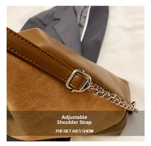 Detail of adjustable shoulder strap on brown matte and smooth leather commuter bag