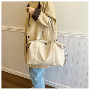 Detailansicht der großen cremefarbenen PU-Shopper mit verstärkten X-Nähten und Metallschnallen