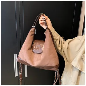Detail of suede tote bag with chain strap and embossed GLAPS bear logo design