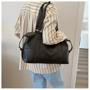 Detailansicht der schwarzen matten PU-Ledertasche mit breiten Griffen und Metallbeschlägen