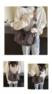 Detailed shot of dark grey nylon crossbody bag with drawstring and plush cloud charm