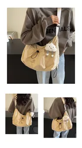 Detailed views of beige crescent crossbody bag with drawstring and plush charm