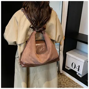 Detail of dual-texture brown leather backpack with claps text and adjustable strap