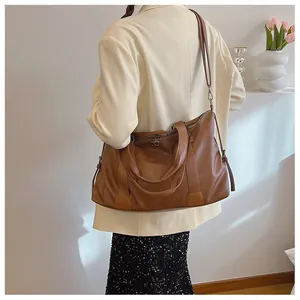 Detailansicht der braunen Leder-Tragetasche mit verstellbaren Riemen und Reißverschluss