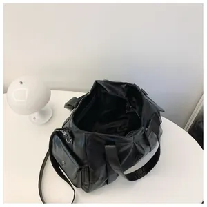 Detail view of large black faux leather tote bag with wide straps and spacious interior