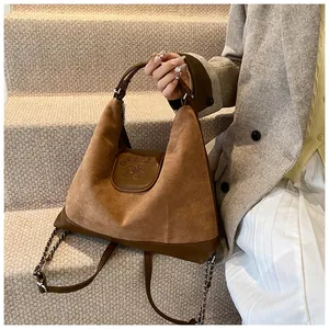Detail of the embossed puppy logo on a brown suede and leather vintage tote bag