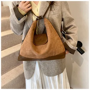 Close-up of brown frosted leather tote bag featuring CLAPS! bear embossing on flap