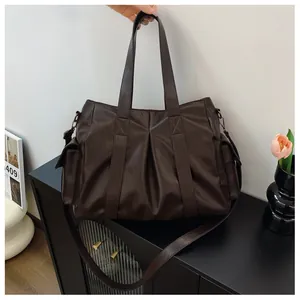 Detail der dunkelbraunen Leder-Shopper-Tasche mit Faltenstruktur und doppelten Trageriemen