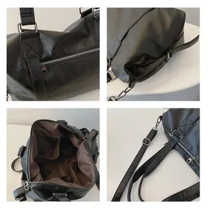 Detailansicht der schwarzen Reisetasche mit Lederstruktur, Reißverschlüssen und Futter
