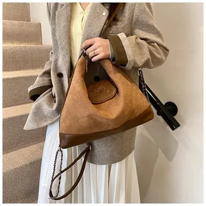 Detail of vintage brown textured leather tote with embossed bear pattern and chain strap