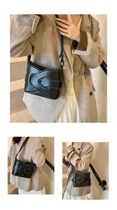Detail of black crescent shoulder bag with white contrast stitching and wavy layered design