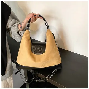 Detail of camel suede tote bag with black leather flap and stylish bear logo engraving