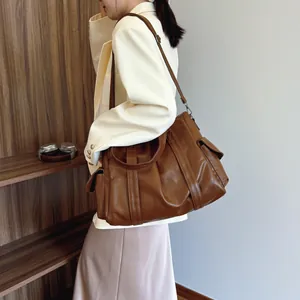 Retro brown large capacity PU leather tote bag with side pocket shown on a female model