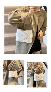 Detail shot of white crescent shoulder bag featuring unique layered architectural design