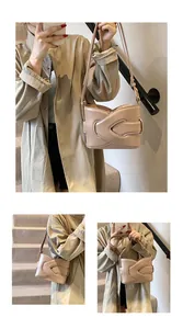 Detail of beige crescent underarm bag with unique cross-wrap strap and matte finish